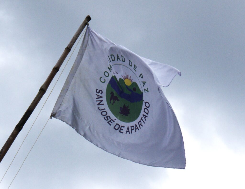 dhColombia Son 19 años de impunidad: masacre de la Comunidad de Paz de San José de Apartadó Bandera comunidad de paz
